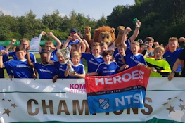 युवा फुटबॉल टीम Slagharen Trophy टूर्नामेंट में ट्रॉफी के साथ जीत का जश्न मना रही है।