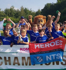 Ifjúsági focicsapat ünnepli a győzelmet trófeával a Slagharen Trophy tornán.