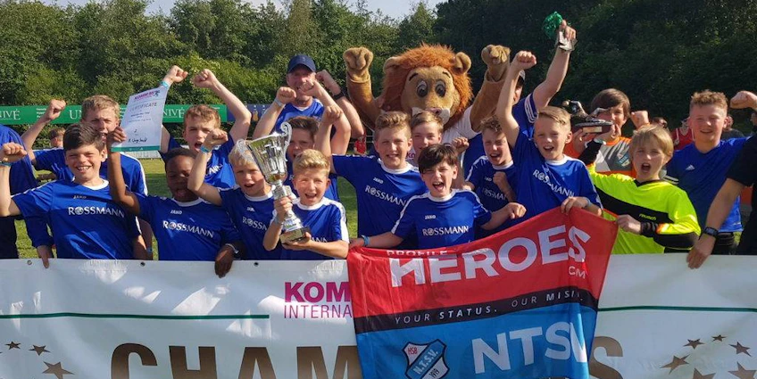 Youth soccer team celebrates with a trophy at the Slagharen Trophy tournament.
