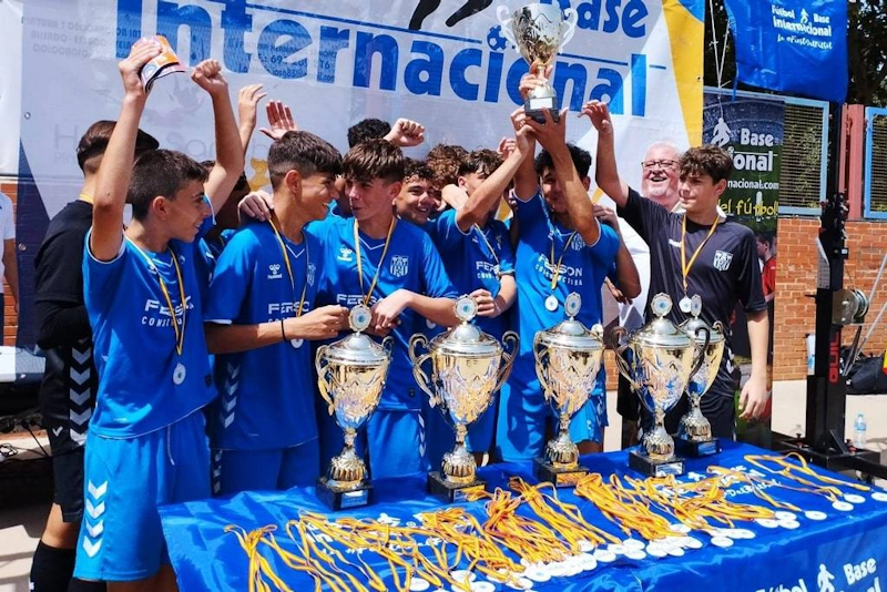 Young footballers celebrating victory with trophies at Madrid International Cup