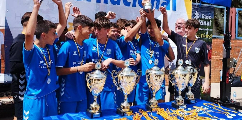 マドリードインターナショナルカップでトロフィーを持って勝利を祝う若いサッカー選手たち