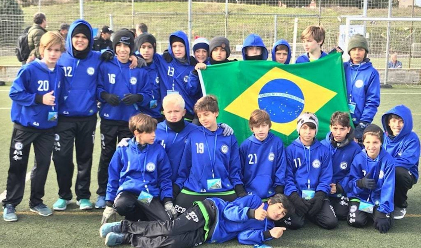 Nuorten jalkapallojoukkue Brasilian lipun kanssa Madridin kansainvälisessä cupissa