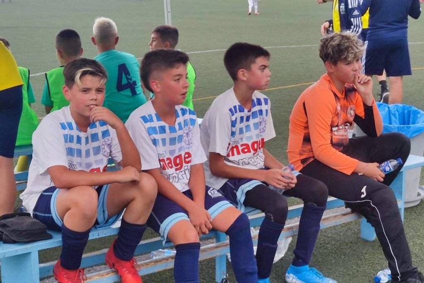 Young footballers resting on a bench during the Costa Levante Cup tournament