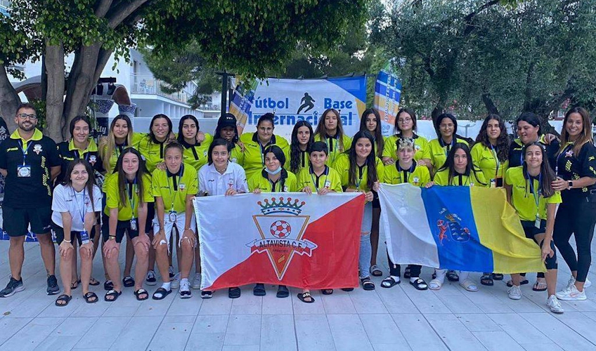 Equipo de fútbol femenino con banderas en la Copa Internacional de Verano