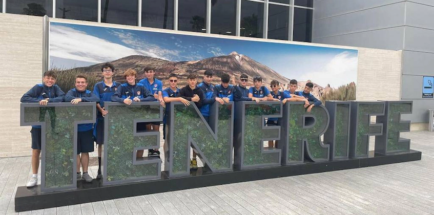 Soccer team posing before the TENERIFE signage at the Canarias Cup.