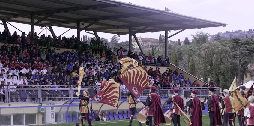 Keskiaikaiset lippukantajat esiintyvät Florence Cupin jalkapalloturnauksessa yleisön edessä.