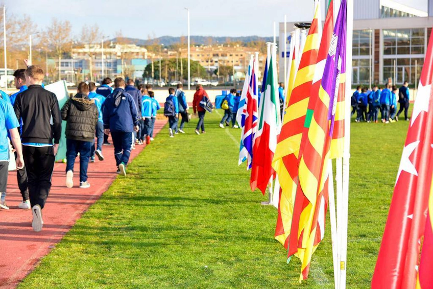 Deelnemers aan het voetbaltoernooi Trofeo San Jaime lopen langs vlaggen