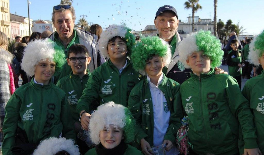 축구 대회에서 녹색 트랙슈트와 흰 가발을 한 어린이 그룹