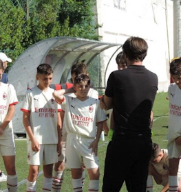 Unga fotbollsspelare lyssnar på sin tränare vid Ischia Cup Memorial Nunzia Mattera-turneringen