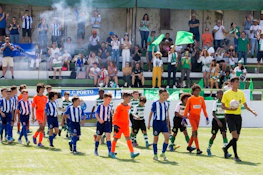 심판과 관중과 함께 그라운드에 들어서는 주니어 축구 팀이 미란다 컵 여름 토너먼트에서.