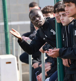 لاعبو كرة القدم الشباب في بدلات يوفنتوس يركزون على اللعبة، مع توضيح أحدهم بالإشارة.