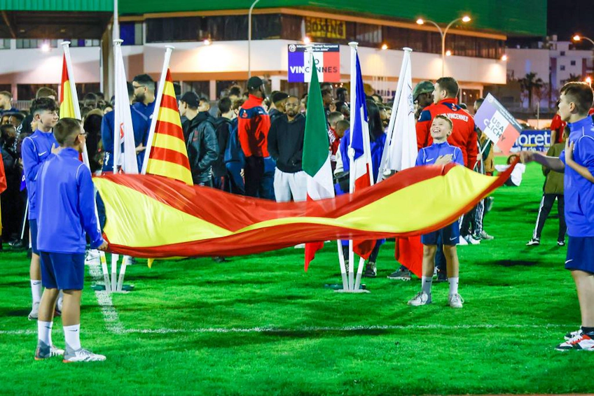 Trofeo Mediterraneoトーナメントの開会式で国際的な旗を持つ若いサッカー選手たち。