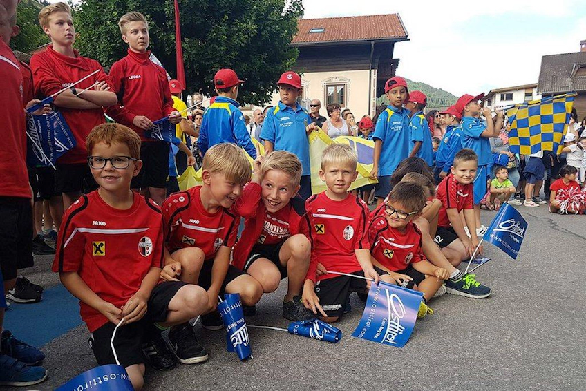 Jonge voetballers in rode shirts met vlaggen op het Trofeo Città di Jesolo festival
