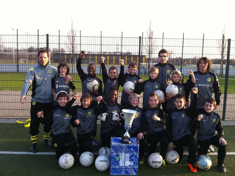 Equipe de futebol juvenil com troféu no torneio Young Talents Cup