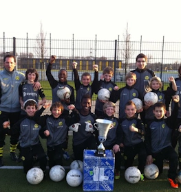 Equipo juvenil de fútbol con trofeo en el torneo Young Talents Cup