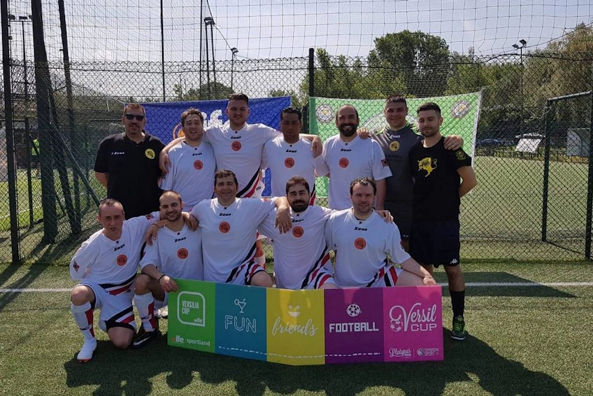 Equipe de futebol no torneio Versilia Cup com uma faixa