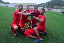 身着红色球衣的足球队在Ibiza Football Fun足球赛中庆祝胜利
