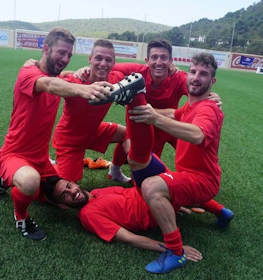 イビサフットボールファンのトーナメントで勝利を祝う赤いユニフォームのサッカーチーム