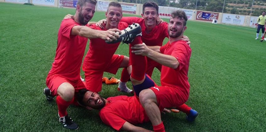 Équipe de football en rouge célébrant une victoire au tournoi Ibiza Football Fun