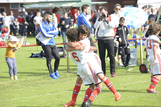 U10 रडाट्ज़ इमोबिलियन कप फुटबॉल टूर्नामेंट में गले मिलते फुटबॉल किट पहने बच्चे