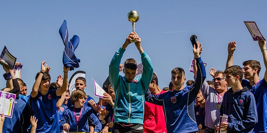 Football team celebrating victory with trophy at Salonica Soccer Cup