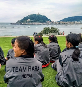 海を背景に休むTeam RARA Nepal女子サッカーチーム