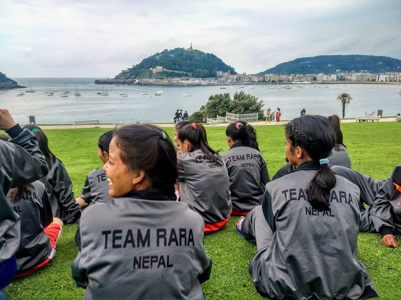 Team RARA Nepal女子足球队在背景海景中休息