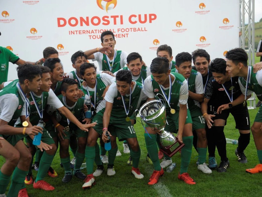 Unga fotbollsspelare firar seger med pokal på Donosti Cup