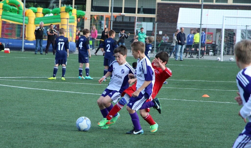 बच्चे Oranje Cup टूर्नामेंट में फुटबॉल खेलते हुए