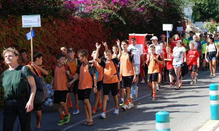 क्रोएशिया फुटबॉल फेस्टिवल में सड़क पर चलते युवा फुटबॉलर और कोच