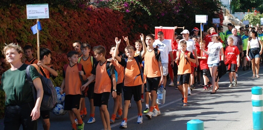Jonge voetballers en coaches lopen op straat tijdens het Voetbalfestival in Kroatië