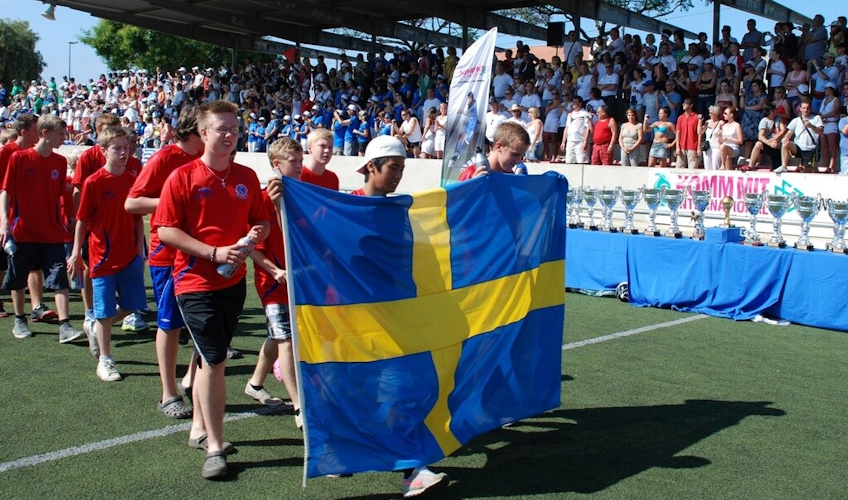 クロアチアのサッカーフェスティバルでスウェーデンの旗を持つ若い選手たち