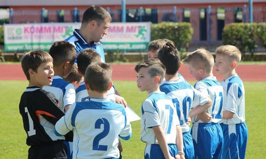 Entraîneur discutant stratégie avec de jeunes footballeurs au tournoi de la Coupe d'Istrie