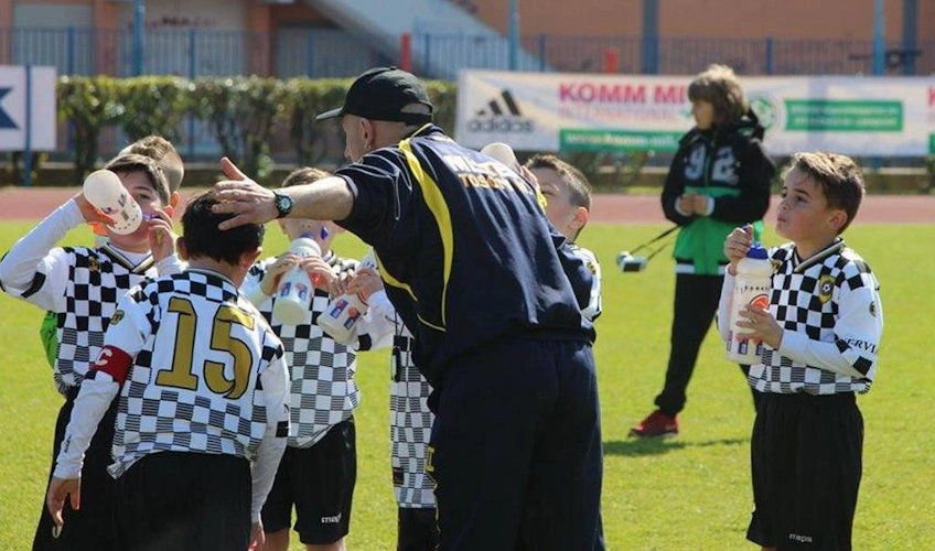 Trainer gibt jungen Fußballern Wasser beim Istria Cup Turnier