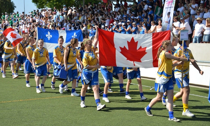Damfotbollslag med Kanadas och Québecs flaggor på International Pfingstturnier