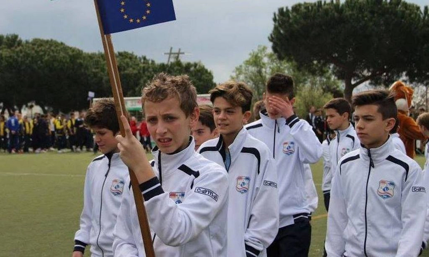 Youth soccer players with the European Union flag at the Copa Santa tournament