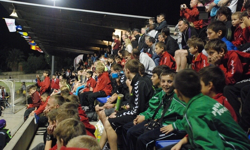 Tineri fotbaliști așezați în tribune la turneul de fotbal Copa Maresme