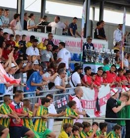 Fans op de tribune met vlaggen bij het Spain Trophy voetbaltoernooi
