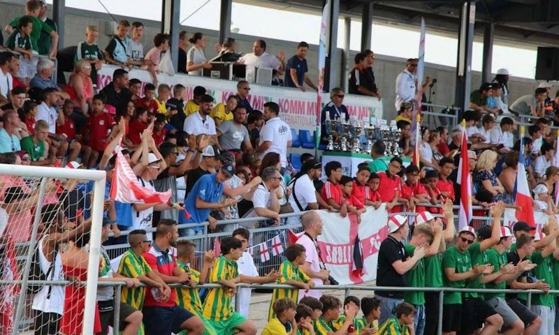 Fans op de tribune met vlaggen bij het Spain Trophy voetbaltoernooi