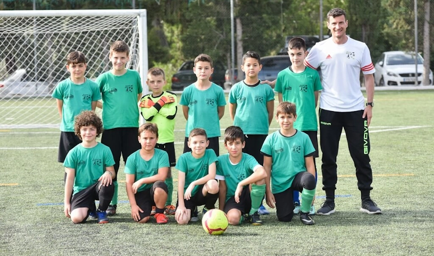 Youth football team with coach on the pitch