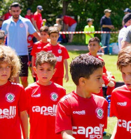 Noored jalgpallurid punastes vormides kõnnivad Pyrenees Cup turniiri väljakul.