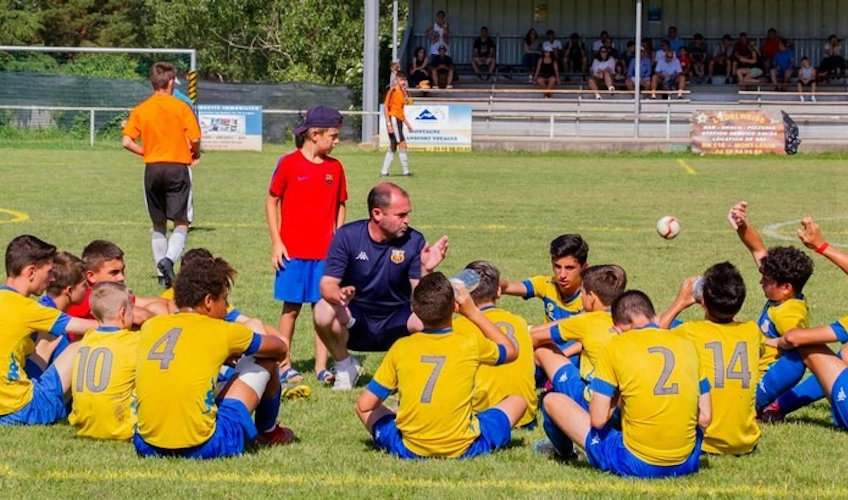 Ifjúsági focicsapat stratégiát tárgyal a pályán