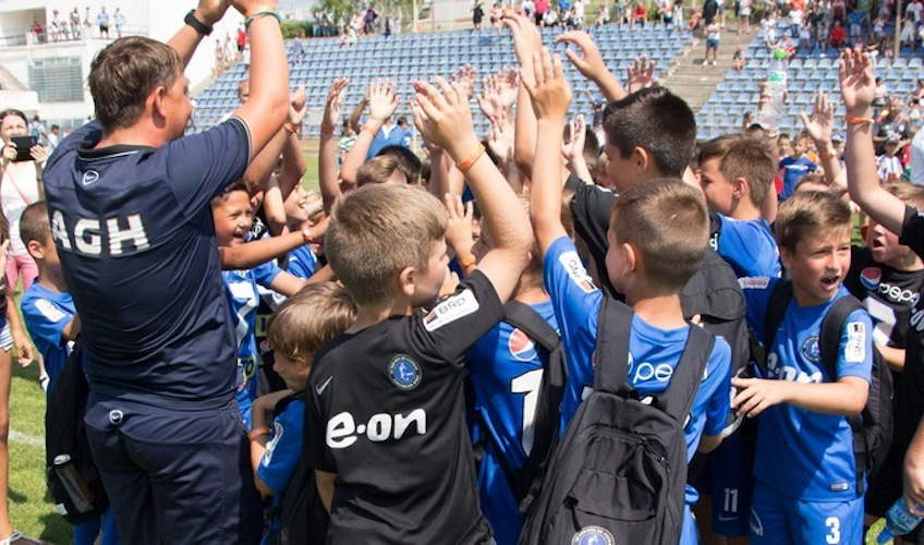 Młodzieżowa drużyna piłkarska świętuje z piątkami na Pucharze Juniorów.